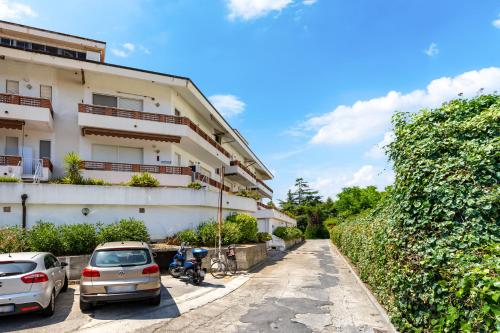 a building with cars parked in a parking lot at Hostdomus - Blumar in Diano Castello