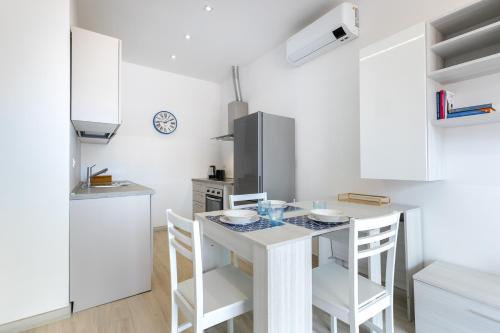 a kitchen with a table and chairs in a room at Hostdomus - Blumar in Diano Castello
