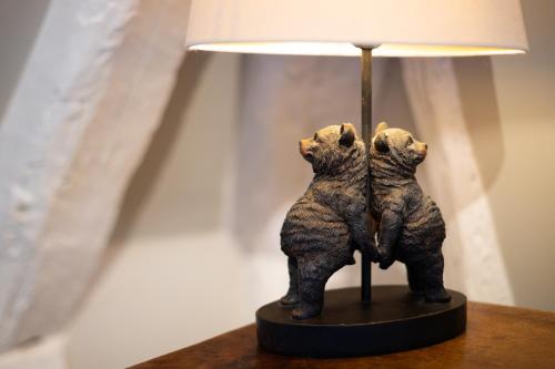 two bear statues sitting next to a lamp on a table at Hôtel La Couleuvrine Sarlat Centre Ville in Sarlat-la-Canéda