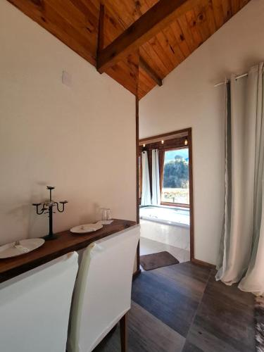 a dining room with a table and a window at Chalés Refúgio no Campo in Santo Antônio do Pinhal