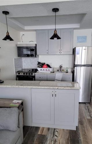 a kitchen with white cabinets and a white refrigerator at Georgian Inn Beach Club in Ormond Beach