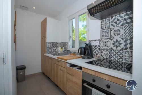 une petite cuisine avec un évier et une fenêtre dans l'établissement Magnifique Appartement avec Extérieur, à Bagnols-sur-Cèze