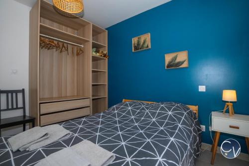 - une chambre avec des murs bleus, un lit et un bureau dans l'établissement Magnifique Appartement avec Extérieur, à Bagnols-sur-Cèze