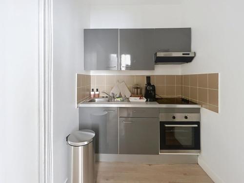 a kitchen with a sink and a stove at Le Charline - 2 chambres in Compiègne