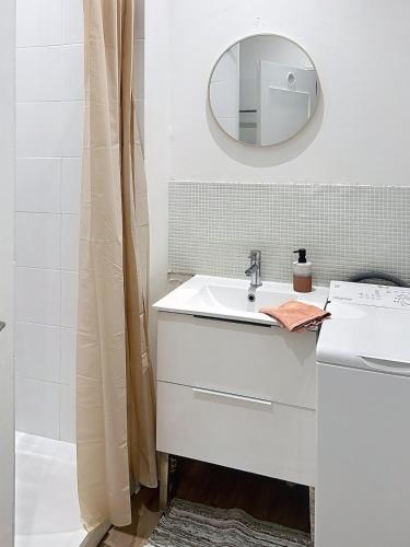 a white bathroom with a sink and a mirror at Le Charline - 2 chambres in Compiègne