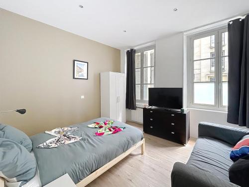 a living room with a bed and a couch at Le Charline - 2 chambres in Compiègne