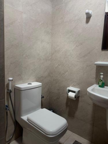 a bathroom with a toilet and a sink at Modern Apartment in Boshar, Muscat in Muscat