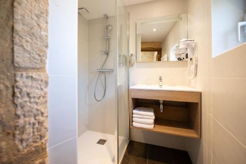 a bathroom with a shower and a sink at Hôtel La Couleuvrine Sarlat Centre Ville in Sarlat-la-Canéda