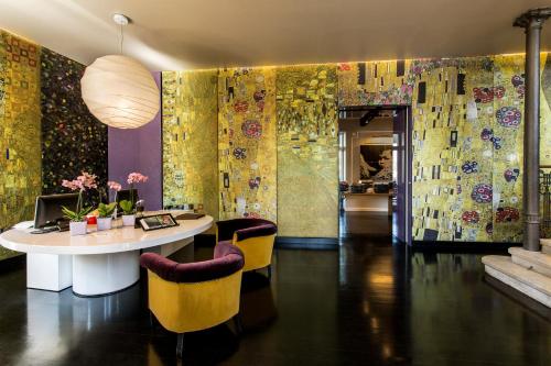 una sala da pranzo con tavolo e sedie gialle di Hotel Bella Riva a Gardone Riviera