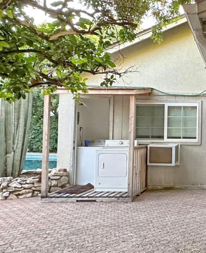 an outdoor kitchen with a stove and a refrigerator at 6BR Pool Escape for Friends and Family - LOU1 - BUR in Burbank