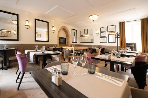 a restaurant with tables and chairs in a room at Hôtel La Couleuvrine Sarlat Centre Ville in Sarlat-la-Canéda