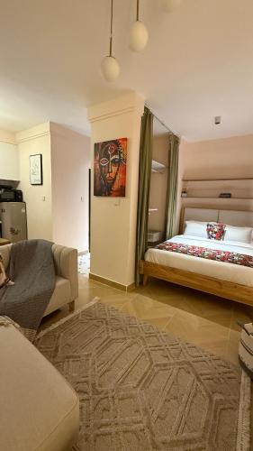 a bedroom with a large bed and a couch and a living room at Chic Retreat Near JKIA and SGR with Nairobi National Park Views in Nairobi