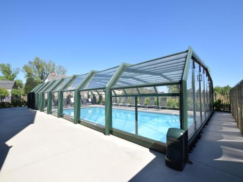 a glass enclosure around a swimming pool at Fancy Holiday Home in Sainte-Cécile with Pool House & Indoor Pool in Sainte-Cécile