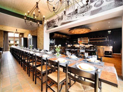 a long dining room with a long table and chairs at Fancy Holiday Home in Sainte-Cécile with Pool House & Indoor Pool in Sainte-Cécile