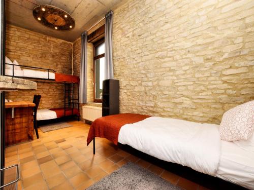 a room with a bed and a brick wall at Fancy Holiday Home in Sainte-Cécile with Pool House & Indoor Pool in Sainte-Cécile