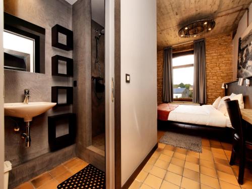 a bathroom with a sink and a bedroom at Fancy Holiday Home in Sainte-Cécile with Pool House & Indoor Pool in Sainte-Cécile