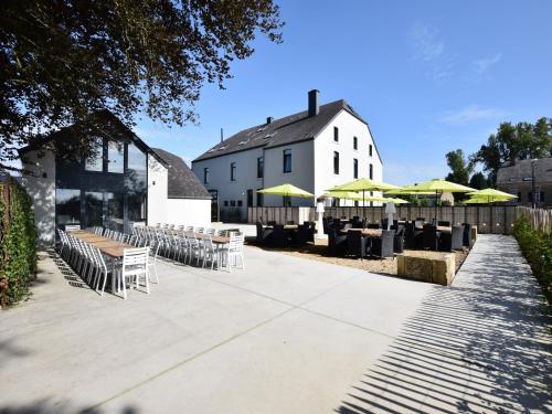 a row of tables and chairs in front of a building at Fancy Holiday Home in Sainte-Cécile with Pool House & Indoor Pool in Sainte-Cécile