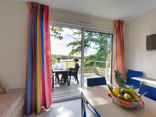 deux personnes assises à une table dans une pièce avec un balcon dans l'établissement Eco Apartment in Loire, à Chaveignes
