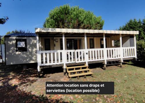 GastesにあるBungalows soit en 3 ou 4ch - jusqu'à 18 voyageurs - mh732 3ch ou mh828 4ch Biscarrosse Lake-proche océanの白柵と玄関のある小さな家
