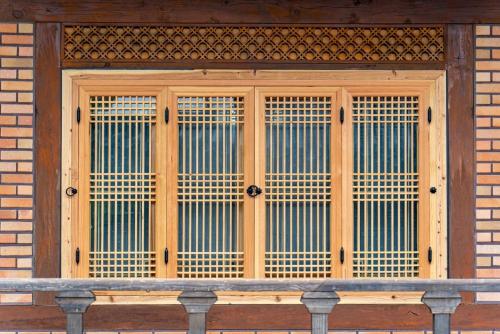 a window with wooden blinds on a brick building at Yongin Yejik Hanok Pension in Yongin