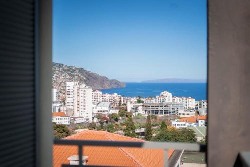 a view of a city and the ocean from a window at Casa da Baía Overlooking Funchal Bay in Funchal