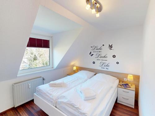 a bedroom with a bed with white sheets and a window at Gorch Fock - 11 in Cuxhaven