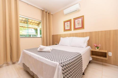 a bedroom with a bed and a window at Refúgio 4 Suítes c/ Piscina, Sinuca e Área Gourmet in Caldas Novas