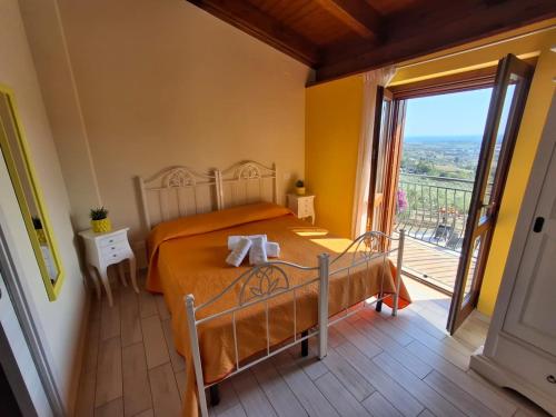 a bedroom with a bed and a large window at Colle Del Mirto in Castelnuovo Cilento