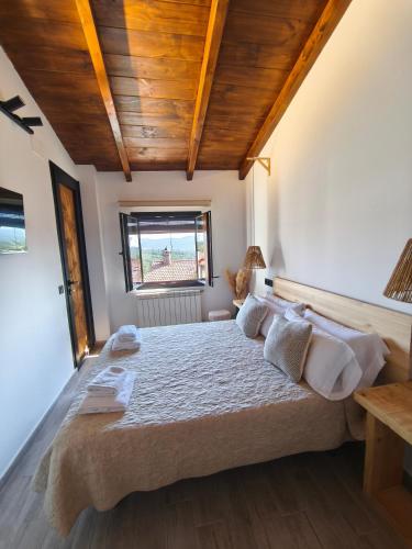 a bedroom with a large bed with wooden ceilings at La Cabaña27 in La Alberca