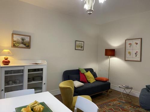 un salon avec un canapé et une table dans l'établissement Appartement lumineux au cœur de Moulins avec balcon, parking et équipements complets - FR-1-489-398, à Moulins