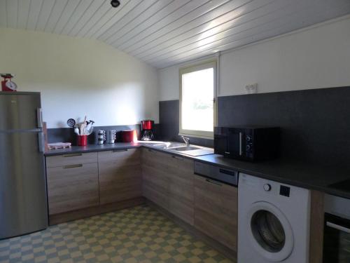 a kitchen with a sink and a washing machine at Grande maison moderne avec jardin, près de châteaux et du Parc Le Pal - FR-1-489-99 in Vaumas