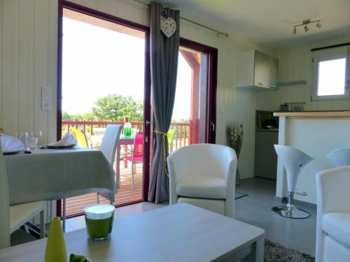un salon avec une table et des chaises et un balcon dans l'établissement Gîte cosy avec terrasse, climatisation et parking - Meillard - FR-1-489-267, à Meillard