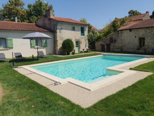 une piscine dans une cour à côté d'une maison dans l'établissement Charmant Gîte avec Piscine Privative et Terrasse à Charroux, Village Médiéval - FR-1-489-394, à Charroux-dʼAllier