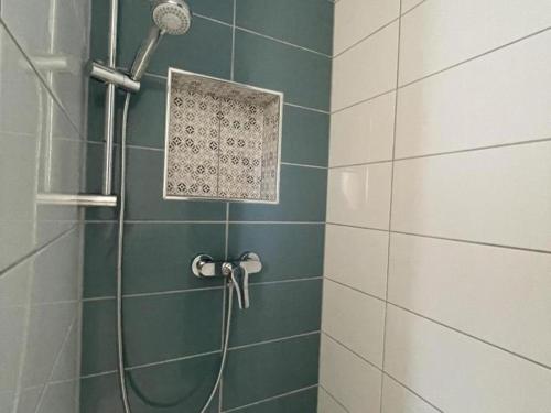 une douche avec pommeau de douche dans une salle de bain dans l'établissement Maison rénovée avec jardin, terrasse et Wi-Fi à Coutansouze - FR-1-489-478, à Coutansouze