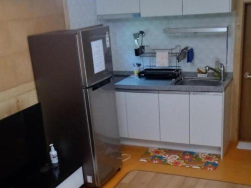 a small kitchen with a refrigerator and a sink at Haneul Cheon Ddaji Hanok in Yangyang