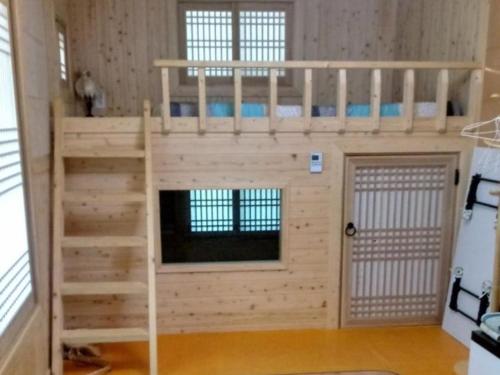 a bunk bed in a room with a ladder at Haneul Cheon Ddaji Hanok in Yangyang