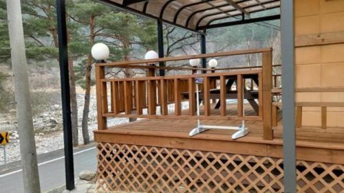 a porch with a wooden bench and lights on it at Haneul Cheon Ddaji Hanok in Yangyang
