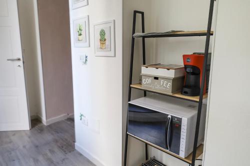 a room with a microwave on a shelf next to a door at Health House in Sassari