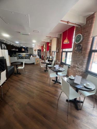 a restaurant with tables and chairs in a room at Trivelles Regency, Nottingham in Nottingham