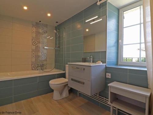 un bagno con un water, un lavandino e una vasca di Maison de charme avec grand jardin, jeux pour enfants, et équipements modernes à Merri - FR-1-497-137 a Merri