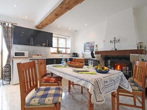une cuisine avec une table et des chaises ainsi qu'une cheminée dans l'établissement Escapade champêtre avec spa et activités en Normandie - FR-1-497-63, à LʼÉpinay-le-Comte