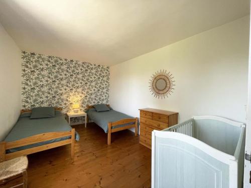 een slaapkamer met twee bedden en een spiegel aan de muur bij Maison spacieuse près du Perche avec jardin et WIFI gratuit - FR-1-497-124 in Bures