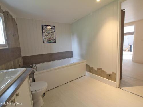 une salle de bain avec une baignoire, des toilettes et un lavabo dans l'établissement Maison calme avec jardin clos, proche Alençon - 3 chambres, équipements complets, animaux acceptés - FR-1-497-162, à Forges