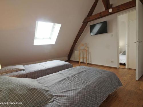 - une chambre avec 2 lits et une télévision murale dans l'établissement Maison calme avec jardin clos, proche Alençon - 3 chambres, équipements complets, animaux acceptés - FR-1-497-162, à Forges