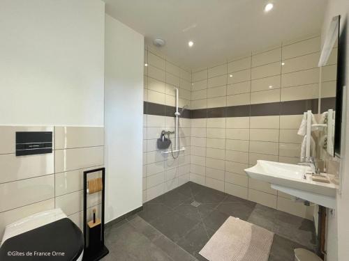 une salle de bain blanche avec un lavabo et une douche dans l'établissement Gîte spacieux dans le Perche avec WIFI inclus, idéal pour réunions familiales - FR-1-497-240, à Val-au-Perche