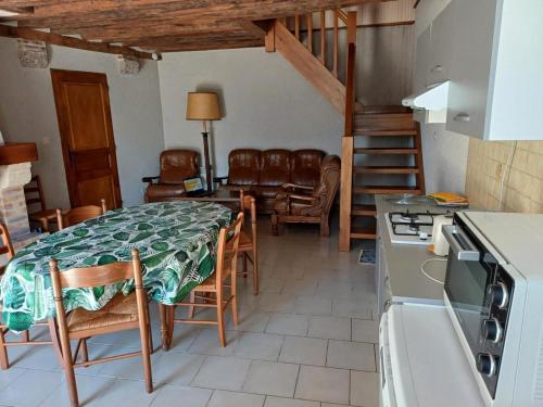 une cuisine et une salle à manger avec une table et des chaises dans l'établissement Maison cosy proche de Blois avec cheminée, cour fermée, animaux acceptés et activités variées à proximité - FR-1-491-351, à Chailles