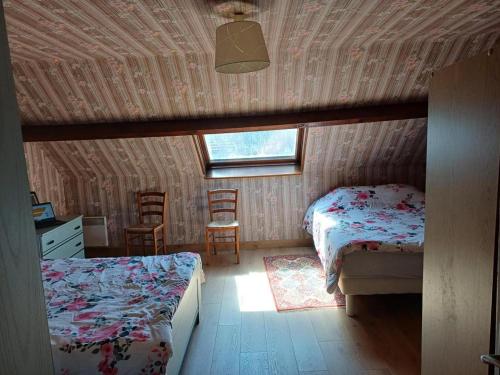 une chambre avec deux lits et un bureau et une fenêtre dans l'établissement Maison cosy proche de Blois avec cheminée, cour fermée, animaux acceptés et activités variées à proximité - FR-1-491-351, à Chailles