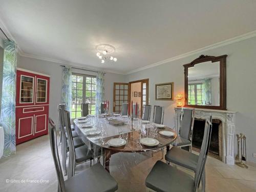 a dining room with a table and chairs and a mirror at Grande maison familiale avec jardin, garage et jeux pour enfants - Parfait pour 15 personnes en Normandie. - FR-1-497-206 in Longny-au-Perche