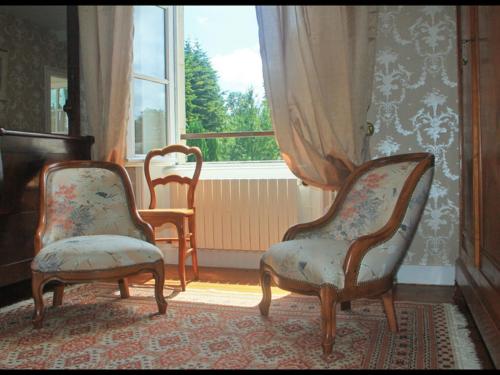two chairs sitting in a room with a window at Grande maison XVIIIème avec jardin clos, ping-pong et option chambres d'hôtes - Animaux acceptés - FR-1-497-193 in Ri