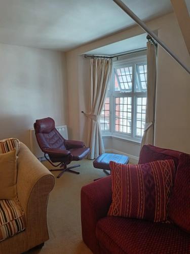 a living room with two couches and a chair and a window at Chandeliers 6 in Shrewsbury